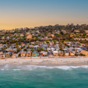 turquoise water beach in Del Mar, CA with homes on a cliff in the background