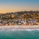 turquoise water beach in Del Mar, CA with homes on a cliff in the background