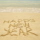 Happy New Year Message written on the beach sand