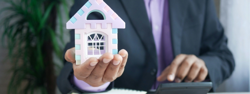 Property Manager holding a house in the right hand